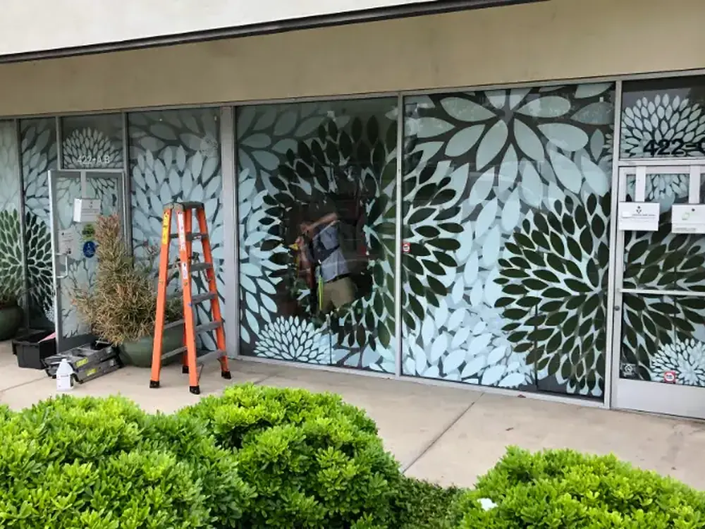 Patterned decorative film screening an office suite frontage from the walkway.